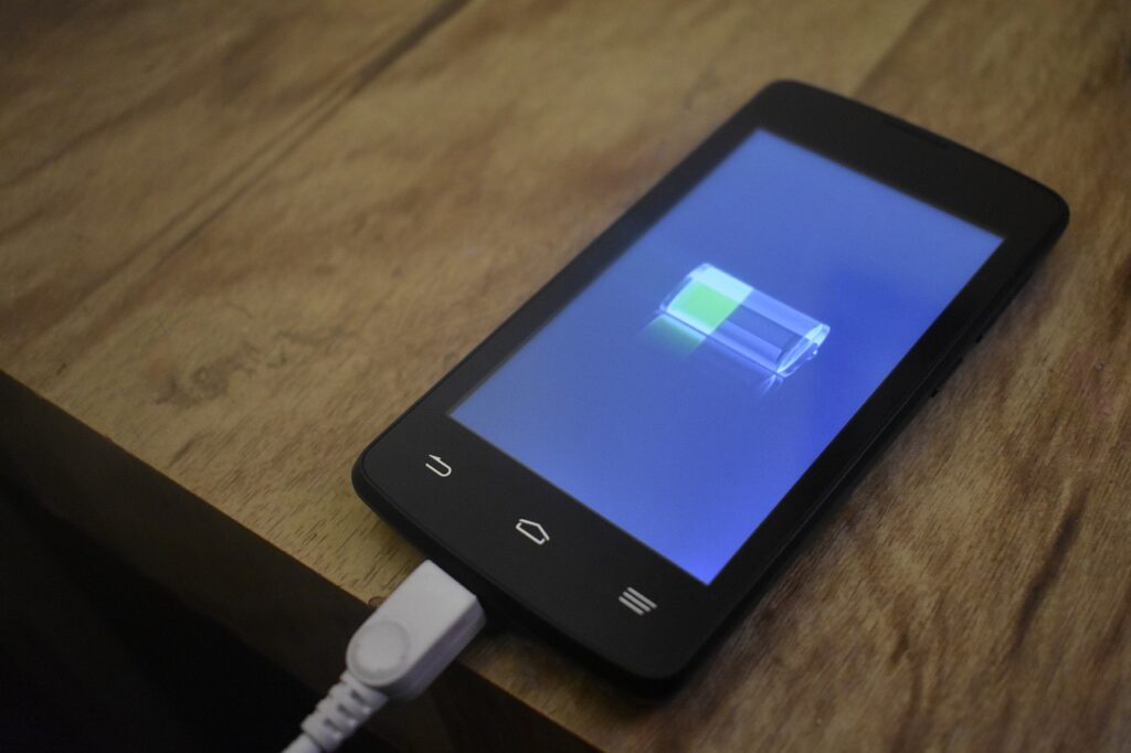 充電中のスマートフォンの画面に電池のアイコンが表示されている